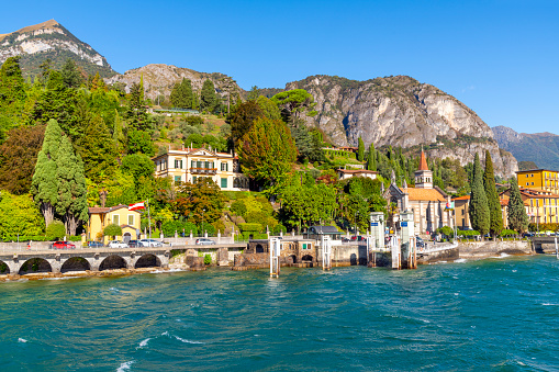The colorful village of Cadenabbia, Italy, on the shores of Lake Como, with church, town, villas and ferry port in view. Lake Como, in Northern Italy’s Lombardy region, is an upscale resort area known for its dramatic scenery, set against the foothills of the Alps.