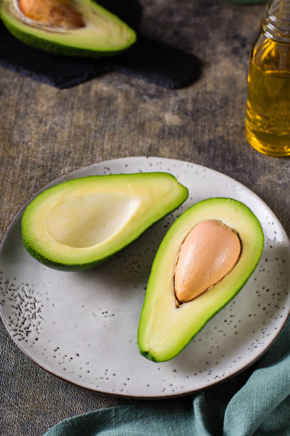 istock Avocado halves on a plate on the table. Healthy vitamin nutrition. Vertical view 1453841974