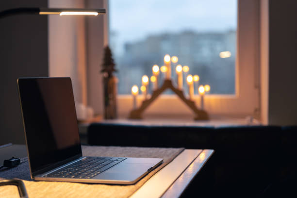 istock Laptop on a table in a room interior with candles on a blurred background. 1453842735