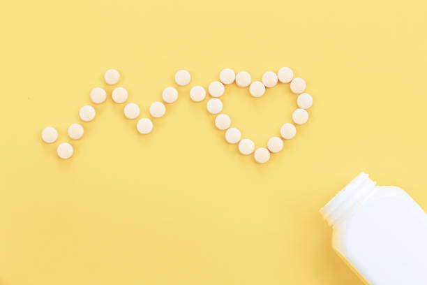 istock Scattered heart shaped pills on yellow background, flat lay. 1453843767