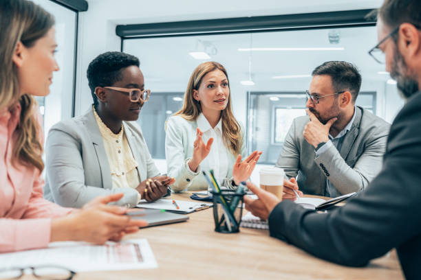 Business meeting Modern business team discussing new ideas at the office. Business people on meeting in modern office. Colleagues smiling and talking at board room. Brainstorming voice stock pictures, royalty-free photos & images