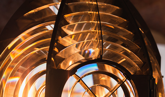 Lighthouse lamp with Fresnel lens mounted on metal frame, close up photo of glass rings