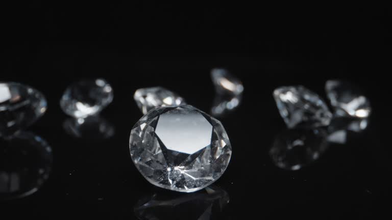 Group of round classic shaped diamonds set on dark reflective surface background