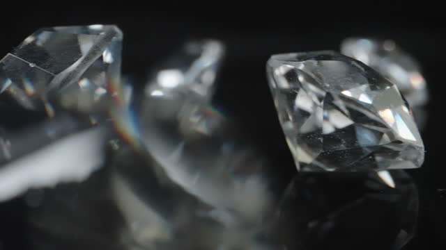 Shiny classic shape diamonds on black surface and background
