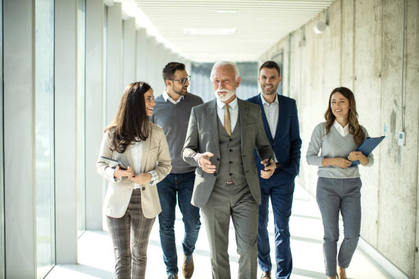 istock Group of business people walking through hallway and talking 1453846360