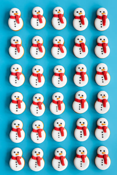 istock Gingerbread snowmen covered with icing on a blue background, flat lay. 1453847544