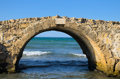 The Venetian Bridge of Argassi in Zakynthos island from Greece. Argassi Bridge is built at the outfall of a river and is today ruined, located 10 meters from the seashore.