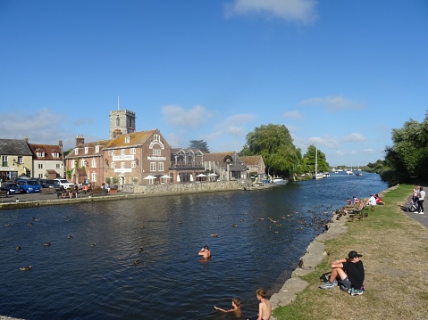 Wareham, United Kingdom – August 02, 2020: The view of people enjoying the sunny day at the River Frome in Dodington Park