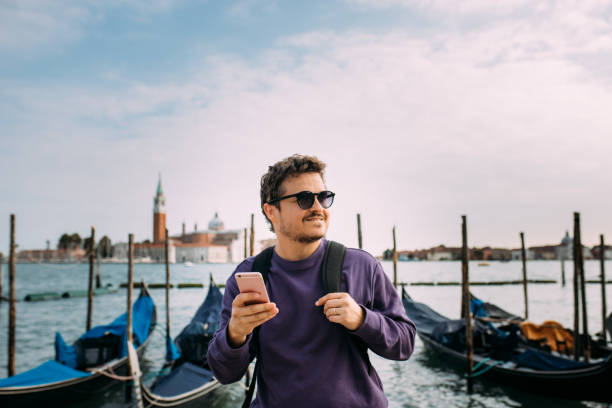 istock Handsome tourist with backpack talking on the phone in venice 1453848647