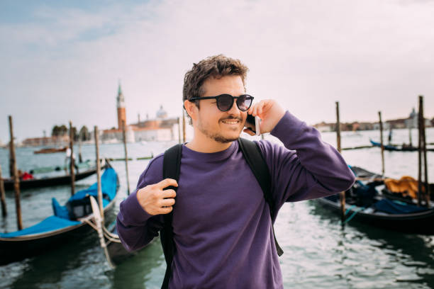 istock Handsome tourist with backpack talking on the phone in venice 1453848670