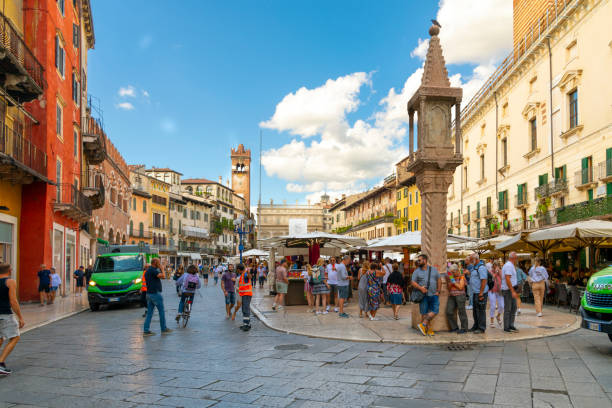 los turistas hacen turismo, compran en el mercado al aire libre y cenan en los cafés de la acera en la histórica piazza delle erbe en el centro de verona, italia. - piazza della signoria fotografías e imágenes de stock