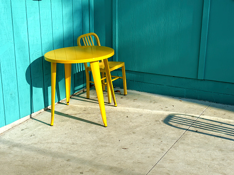 Colorful metal table and chairs on empty terrace in rainy day cafe in Asturias (Spain)