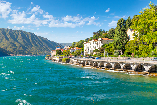 View over the Lake Garda on Malcesine. Malcesine located on the eastern shore of the lake in the Province of Verona (Veneto), is the most popular and scenic town at the Lake Garda. Ferry boats are crossing the Lake, with the European Alps of Trentino-Alto Adige in the distance