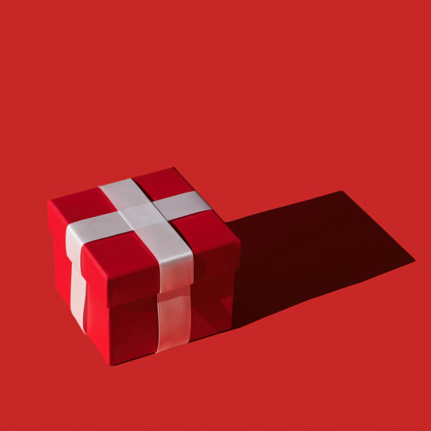 istock Single red gift box with ribbon on red background. 1453858913
