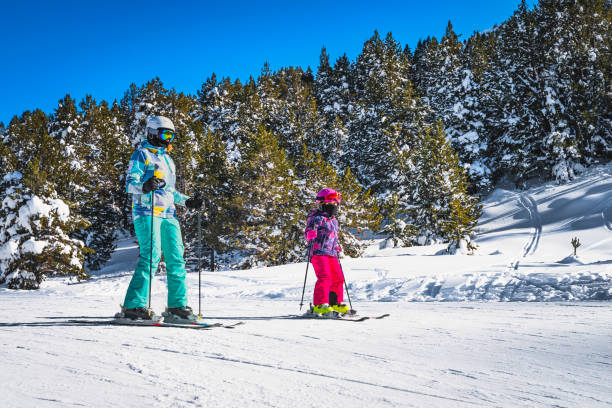 Closeup of mother and daughter skiing down a slope on a winter ski holidays in Andorra stock photo