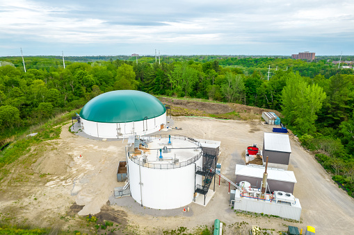 Biogas plant green summer public park. Renewable energy from biomass and animal manure. Modern agriculture in North America. Aerial view.