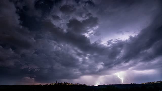 Time lapse. Beautiful thunderstorm with clouds and lightning over the night city