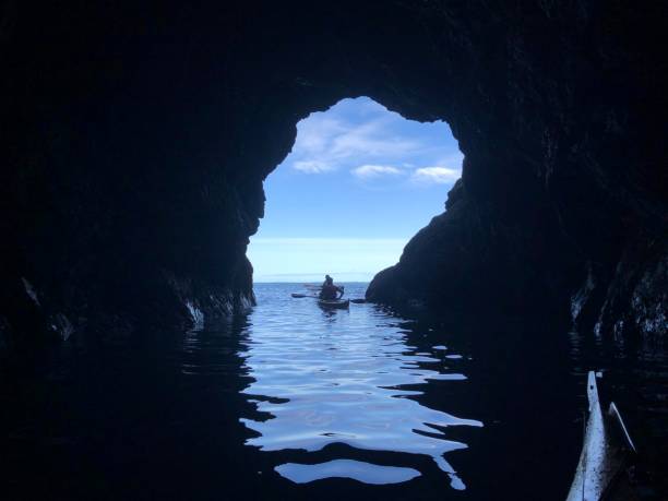 海の洞窟を探索する - kayaking kayak sea coastline ストックフォトと画像