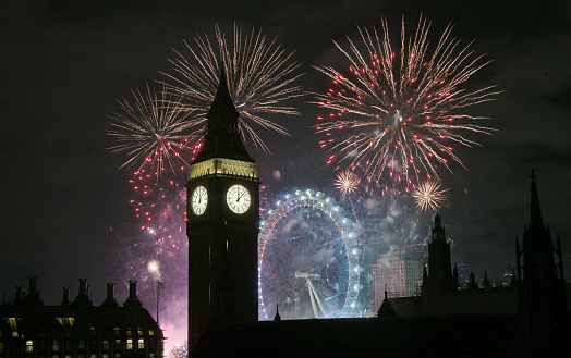 New Years fireworks display set against the iconic London Westminster skyline and Big Ben clock tower showing midnight on new Year;s Eve