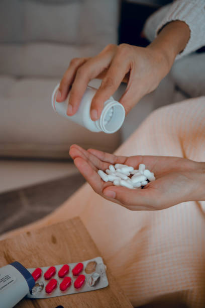istock woman's hand and hand taking medicine 1453866831