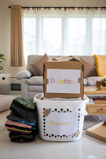 Donation Concept. Box of Cloth with Donate label.  Old Garment at Home.