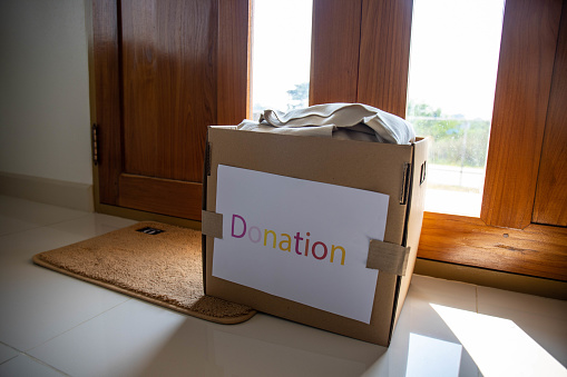 Donation Concept. Box of Cloth with Donate label.  Old Garment at Home.
