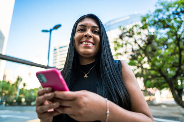 istock Business woman using cell phone cityscape 1453868565