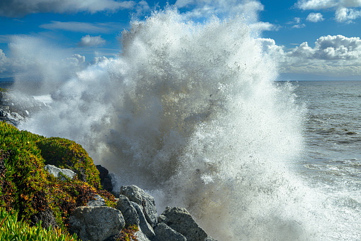 Turbulent ocean waves crashing along the California coast, under a cloudy sky, where a storm had just passed  through.\n\nTaken at Santa Cruz, California, USA