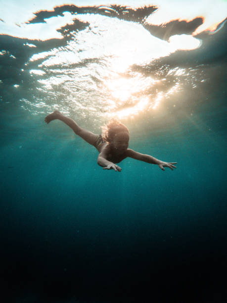istock Curious Young Kid Diving Underwater While On Family Vacations 1453869483