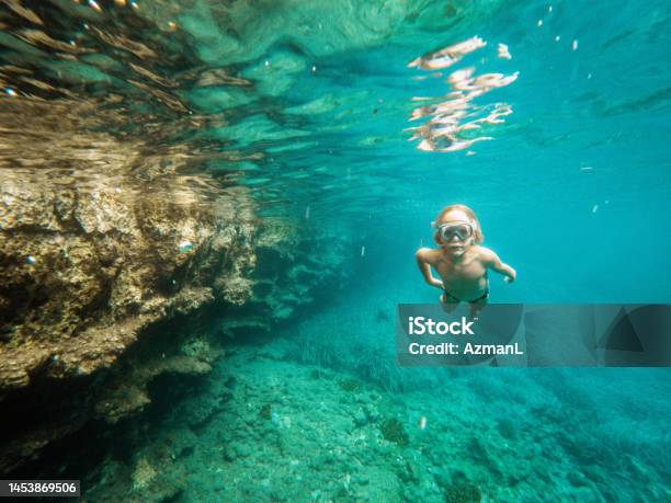 Small Caucasian Boy Diving Underwater And Exploring In The Sea Stock Photo - Download Image Now