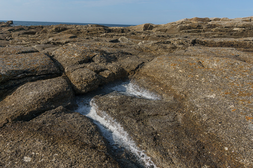 Boulder with hollow filled with salt from evaporated water on the coast