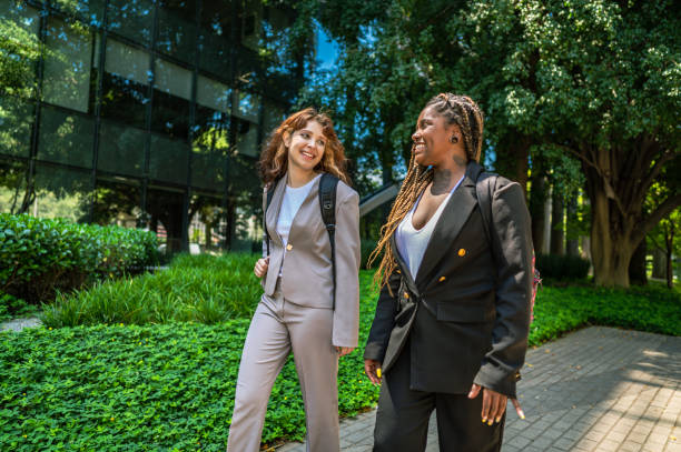 istock women friends from work walking to work talking and smiling 1453869822