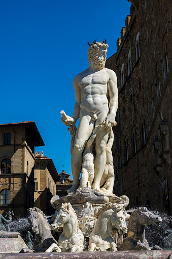 Statue of Caco, the clock tower in the background. Udine Friuli Italy