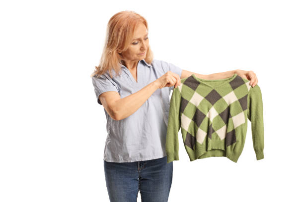 mature woman holding a green sweather - shrank imagens e fotografias de stock