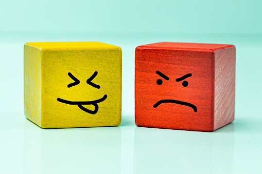 Emotions, Yellow, smiling and red, upset wooden block, hand painted facial expression, positive mindset and angry expression, light pastel background