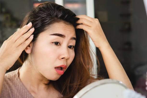 istock stress Asian woman having problem with grey hair 1453882365