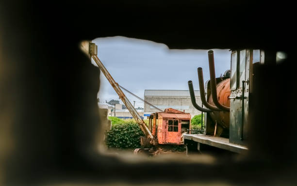 View through hole in wall to old vintage red crane past it's used by date.