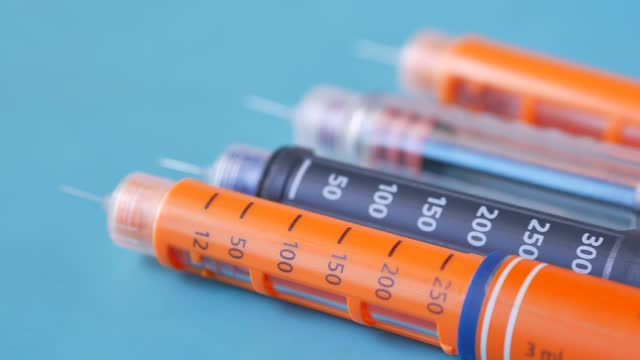 Insulin pens on wooden background, close up