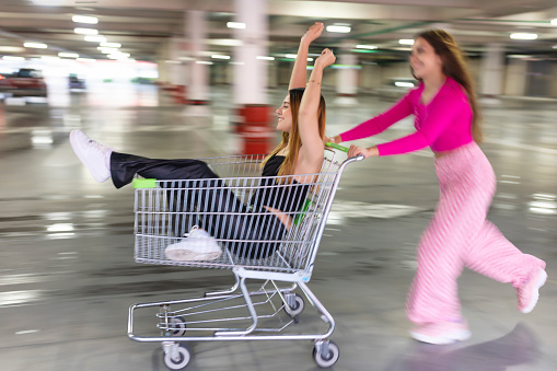 Friends speeding around in shopping cart