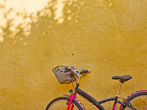 Bicycle propped up on a rustic plaster wall in the Tuscan town of Pienza  Italy