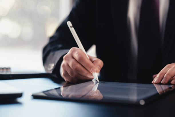 istock Businessman Signing Digital Contract On Tablet Using Stylus Pen 1453897746