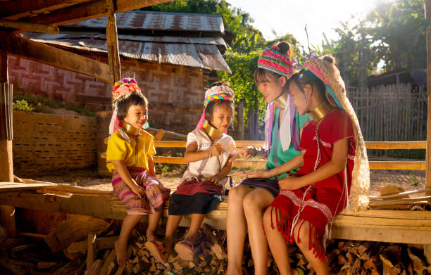 Group of Asian girls and woman of Long Neck Karen Village enjoy to play with rock-paper-scissors game in basement of their house with warm light. Group of Asian girls and woman of Long Neck Karen Village enjoy to play with rock-paper-scissors game in basement of their house with warm light. padaung tribe stock pictures, royalty-free photos & images