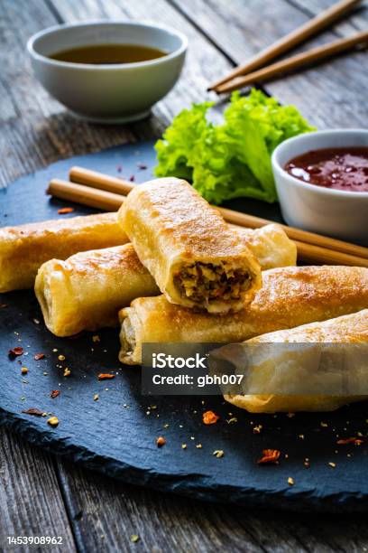 Spring Rolls Filled With Meat And Vegetables Served With Soy Sauce On Wooden Table Stock Photo - Download Image Now