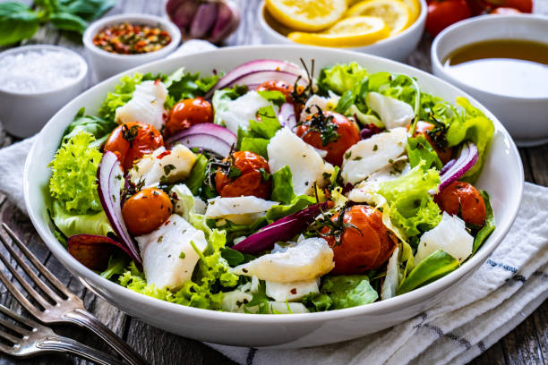 istock Roast fish and vegetable salad  on wooden background 1453909755