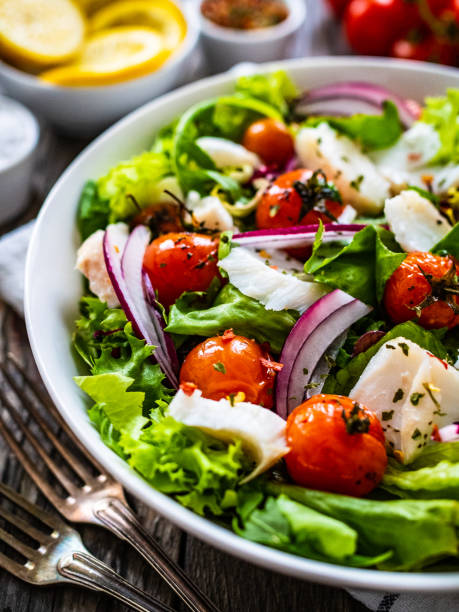 istock Roast fish and vegetable salad  on wooden background 1453909769