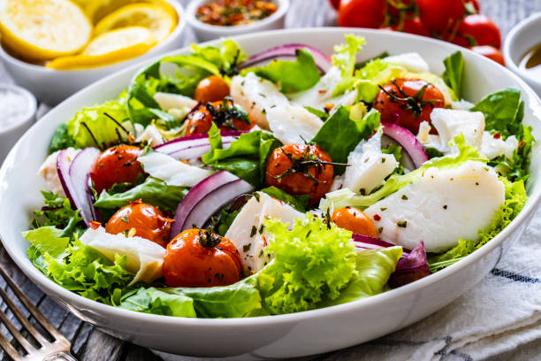 istock Roast fish and vegetable salad  on wooden background 1453909774