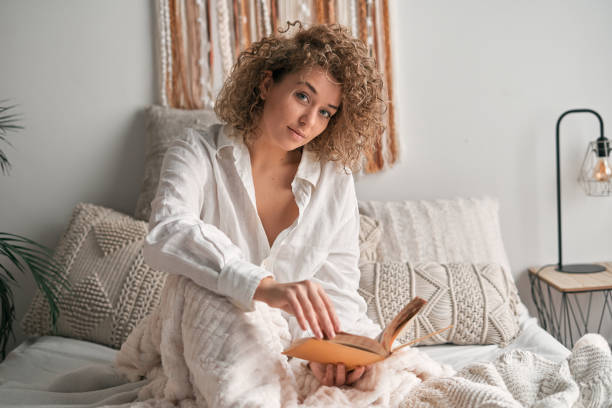 istock Young woman with book looking at camera 1453911010