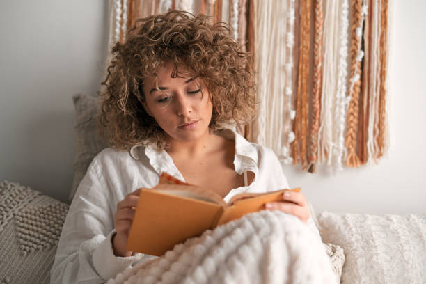 istock Young woman enjoying reading in weekend morning 1453911039