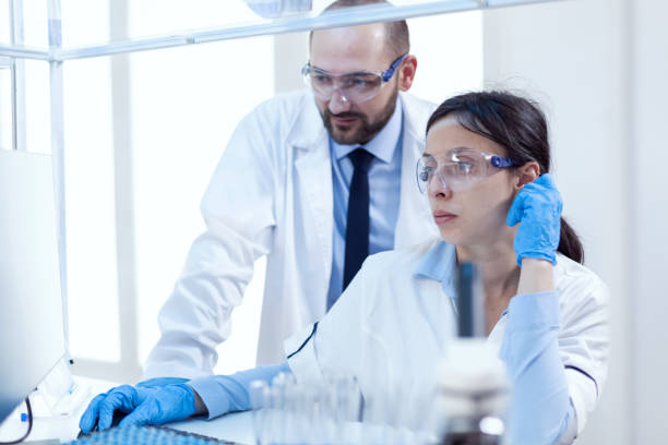 istock Male scientist helping assistant with genetic study 1453913494
