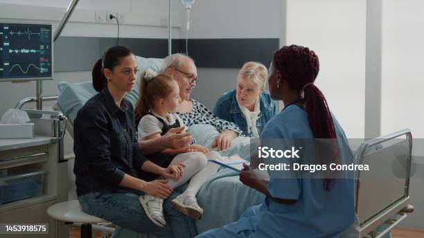 Medical Assistant Talking About Diagnosis With Woman In Visit Stock Photo - Download Image Now